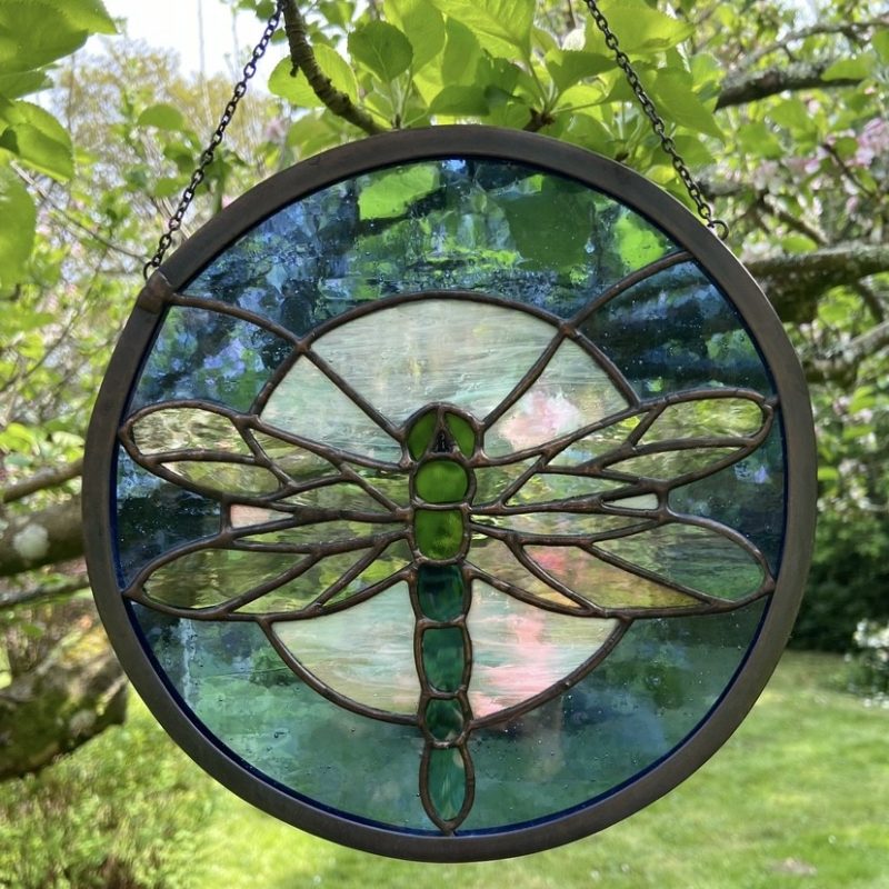 Dragonfly with outspread wings flying in front of the full moon against a deep blue night sky, each one is unique and glass used will differ.