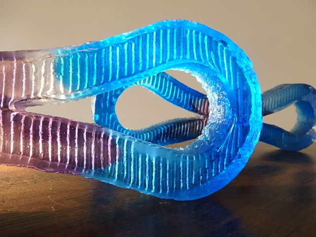 Two Blue Glass Infinity  shapes  suspended in space
