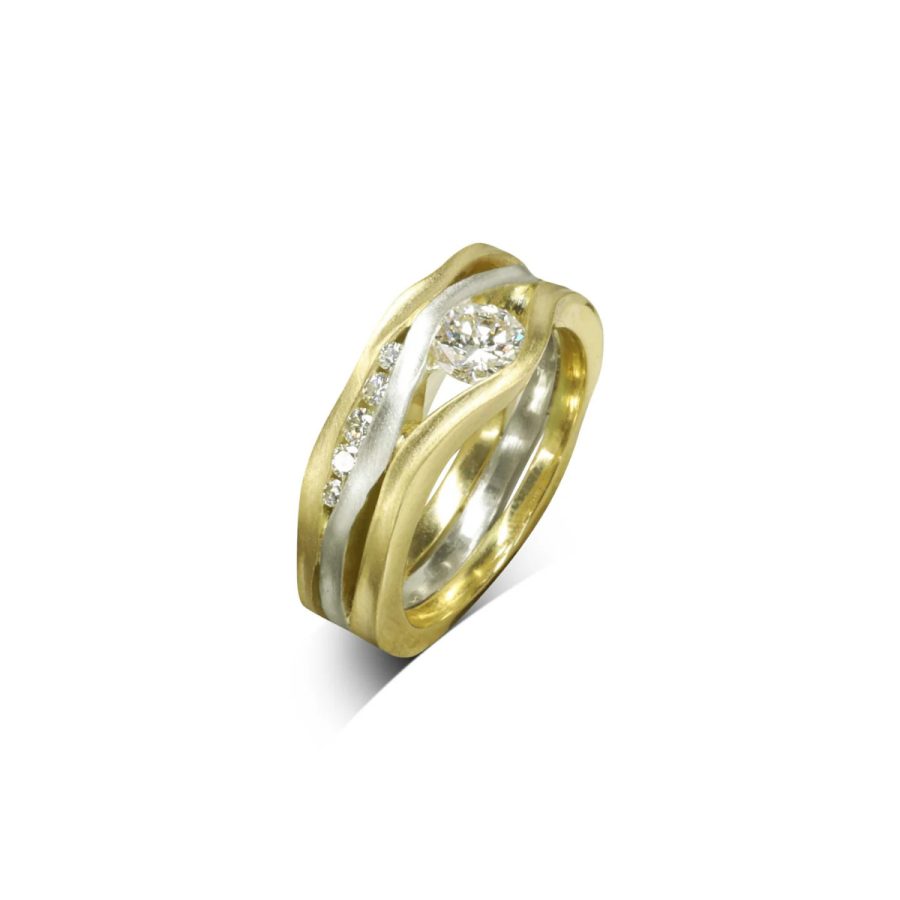 A ring made from three square wires that have been hammered on the side to make them undulating. Diamonds of various sizes are set between the bands. the outer two are yellow gold and the inner one is white gold.