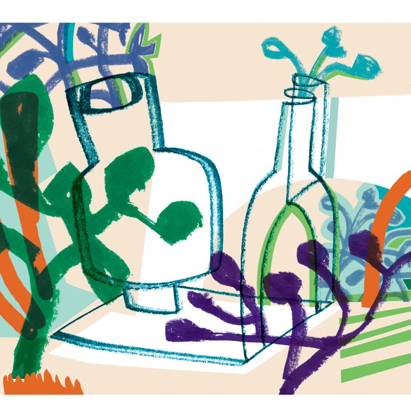 Green, white, purple and orange large glass bottles in a garden.