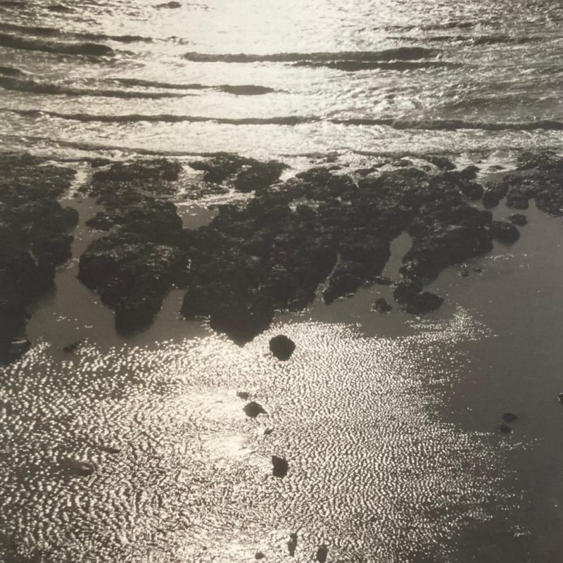 Light shimmering and glinting on the ripples of a sandy beach