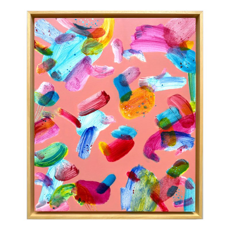Vibrant colourful abstract painting. Various translucent and glowing coloured shapes and marks within a rusty pink background. The rectangular painting is framed in natural wood. 