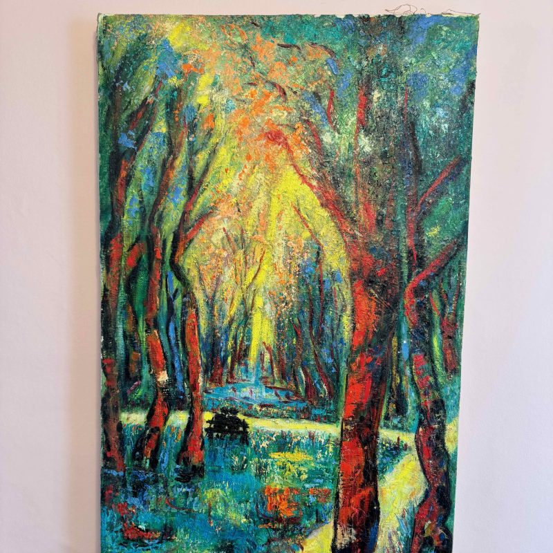Exressionist style. Highly colourful forest scene with a yellow path  going diagonally from the bottom left to the right middle edge of the painting. The path branches left across the middle of the painting with 2 individuals sitting on a bench by the path. Highly colourful trees go to the top of the painting with vivid yellow, blue and red paint thickly applied. There appears to be a pond in the distance with yellow lighting up the trees. 