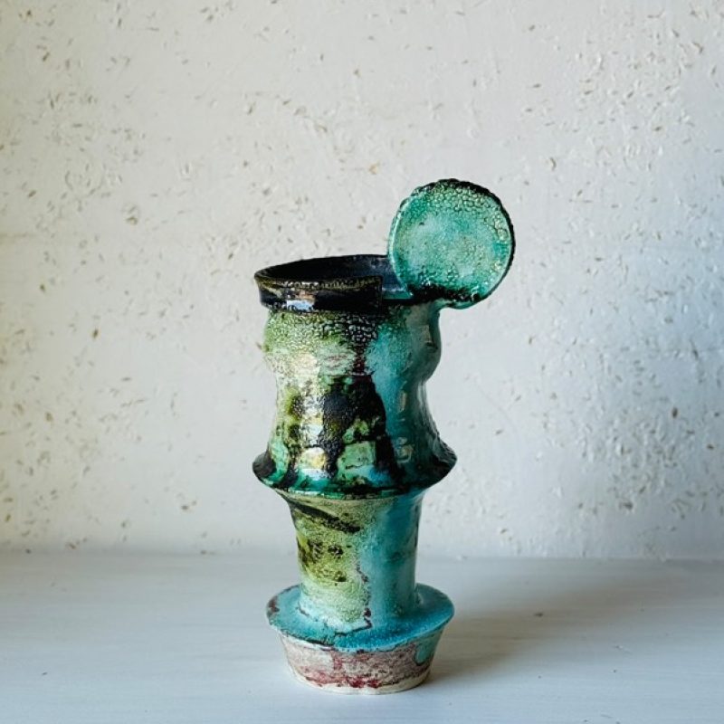 blue green ceramic vase wth a handle
