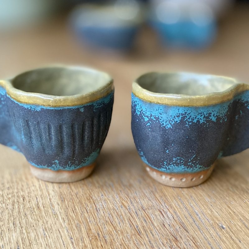 A set of two blue and mustard espresso cups