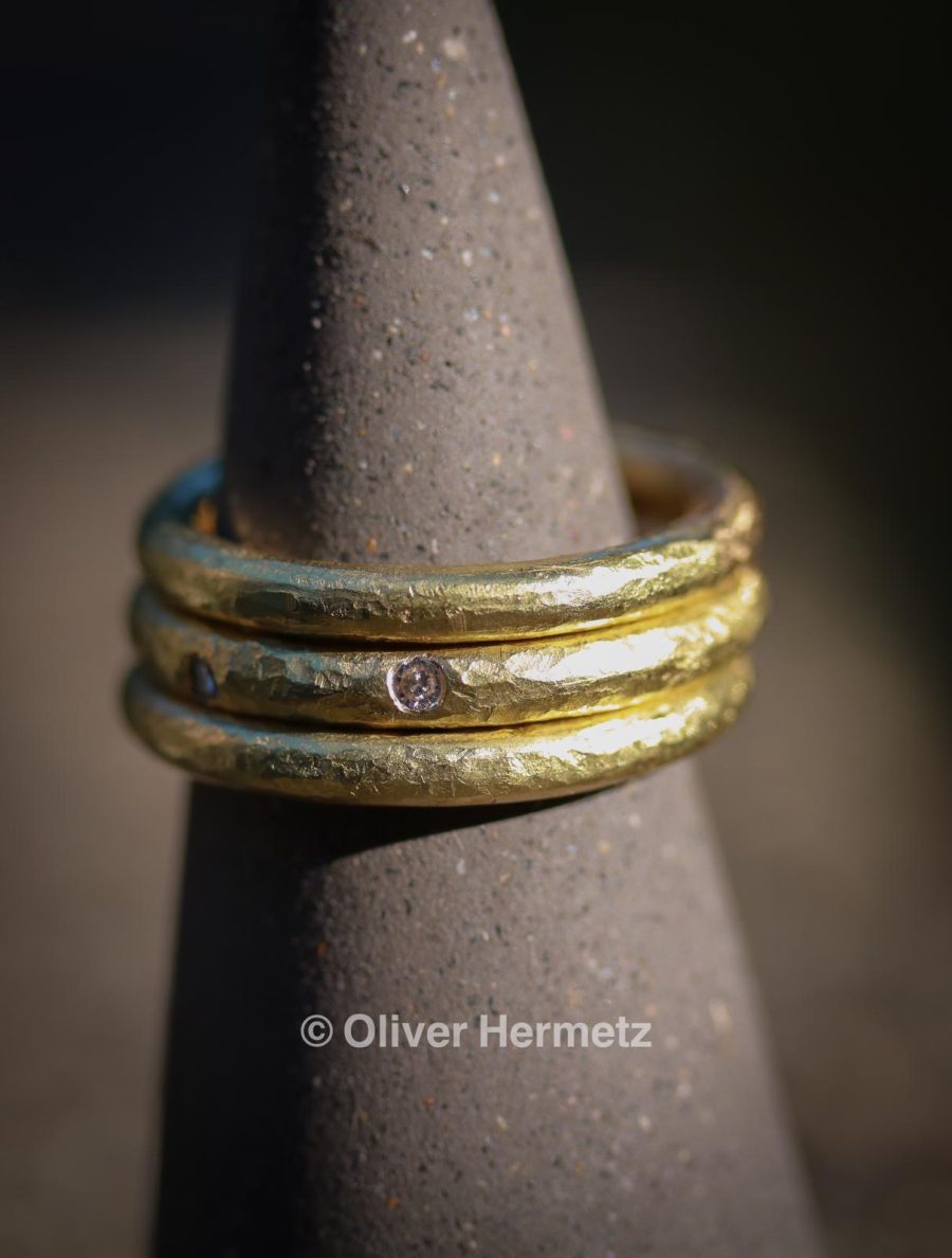 Three Textured hammered stacking gold rings with five diamonds flush set.