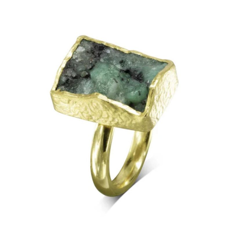 Ring with a rectangular rough cut emerald in a textured matt gold mount on a D section band