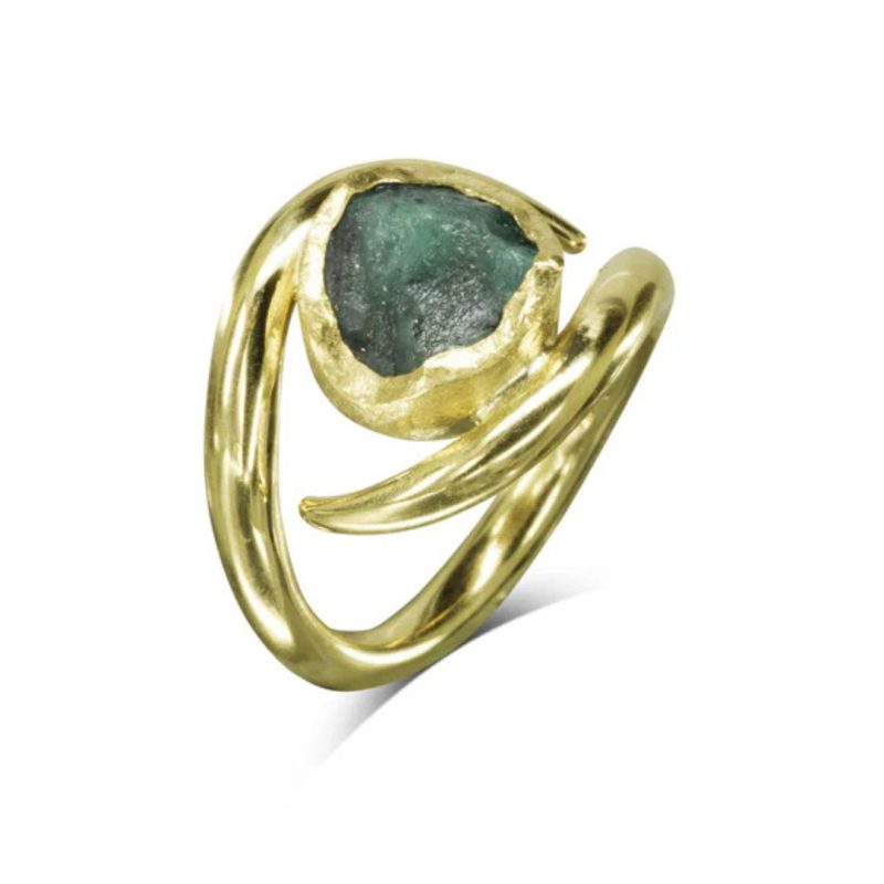 A gold ring with a curved gold spiky band enclosing a green rough emerald