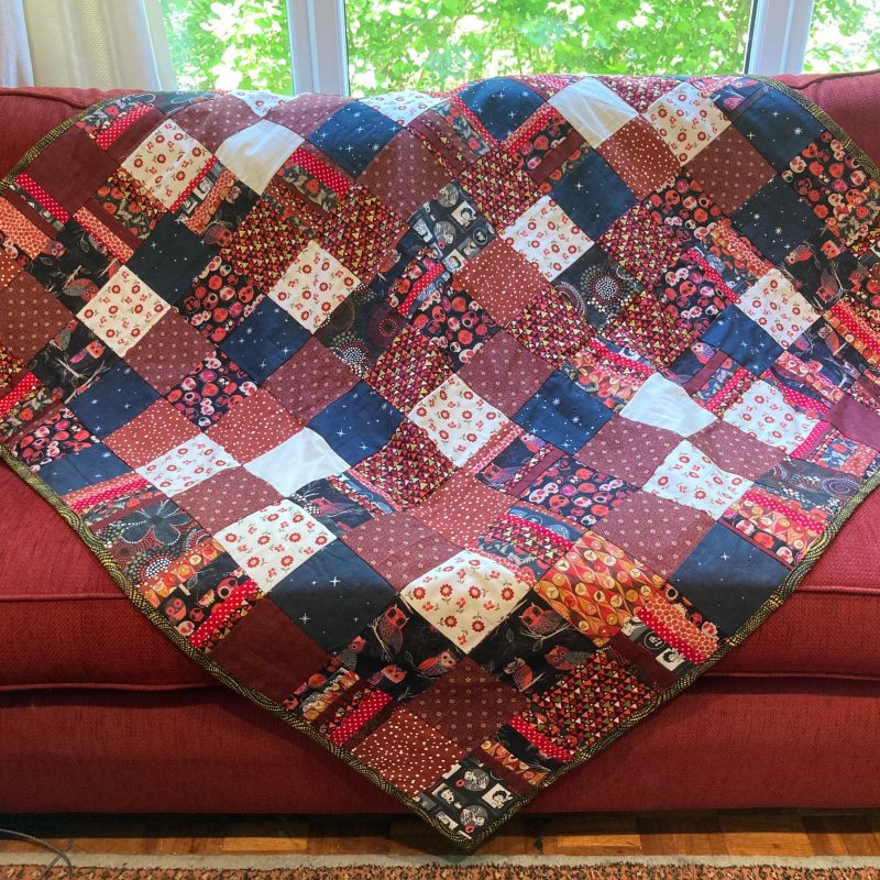 Multi patchwork quilt in flowery and plain patches.