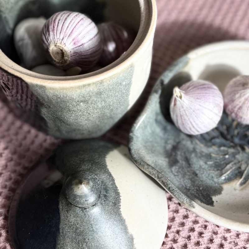 An image showing stoneware ceramic garlic keeper and grating plate and garlic
