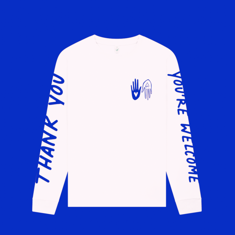Long sleeved white t shirt with blue screen printed graphics. 'Thank you' along one sleeve and 'You're welcome' along the other. Two hands with hearts are printed in small as a pocket print. 