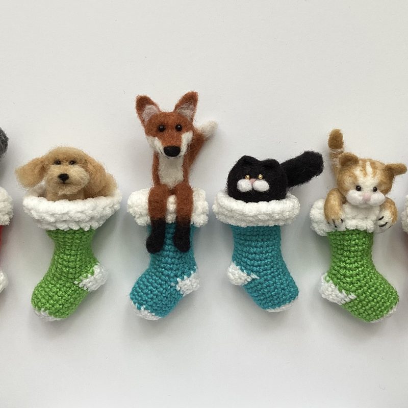 Needle felted animals in stockings as hanging tree decorations