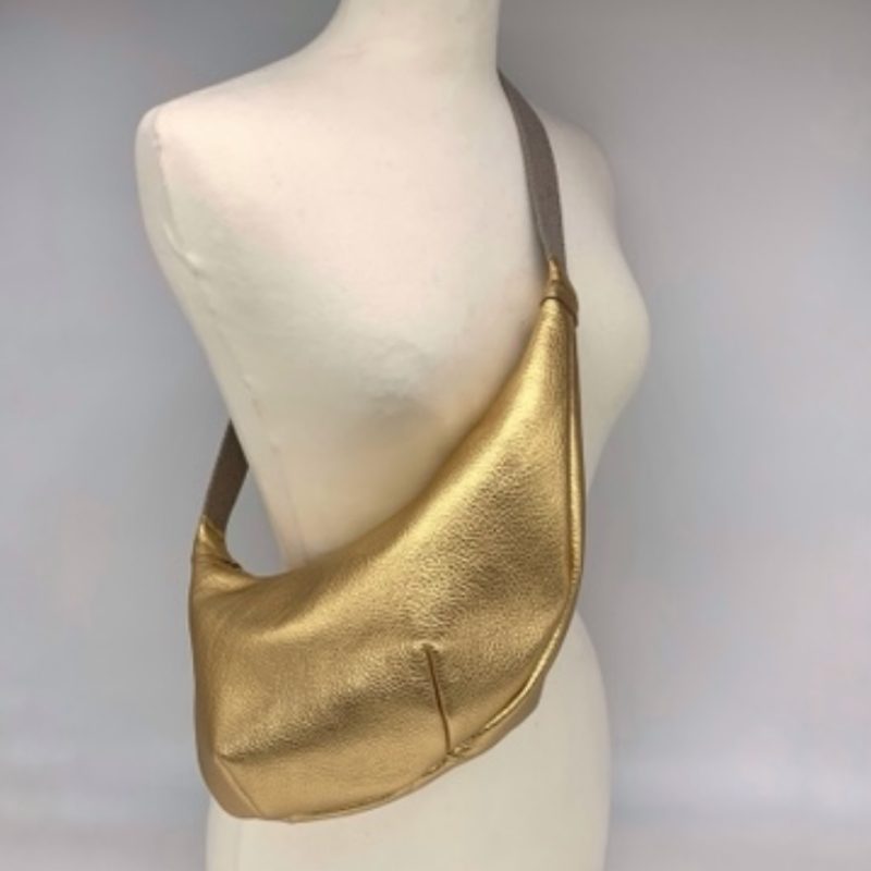 Gold leather crossbody bag on mannequin