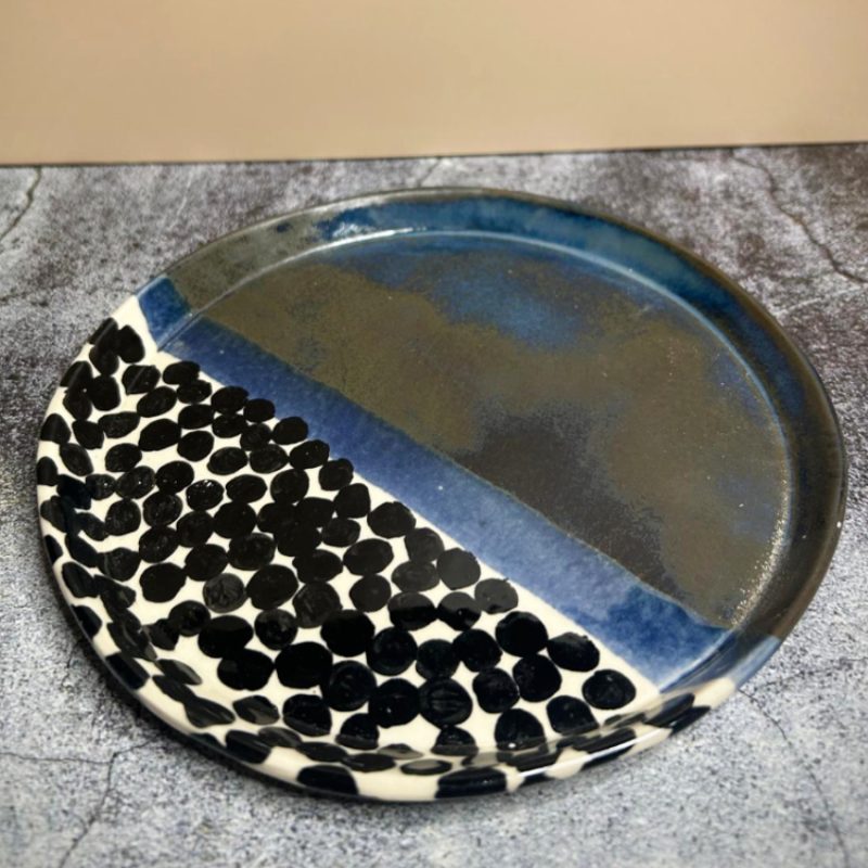 A ceramic plate with blue, black and white design