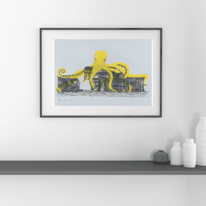 A framed print of a giant yellow octopus engulfing the Brighton West Pier
