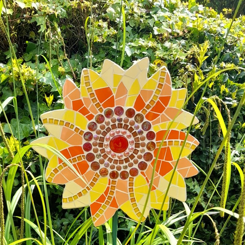 Mosaic garden ornament in the image of a sunflower in vibrant orange and yellow hues
