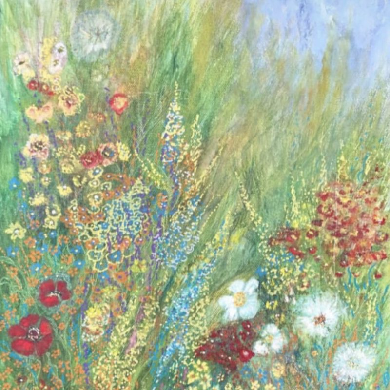 Wild flowers emerge from the green grasses creating a sway of a natural bouquet