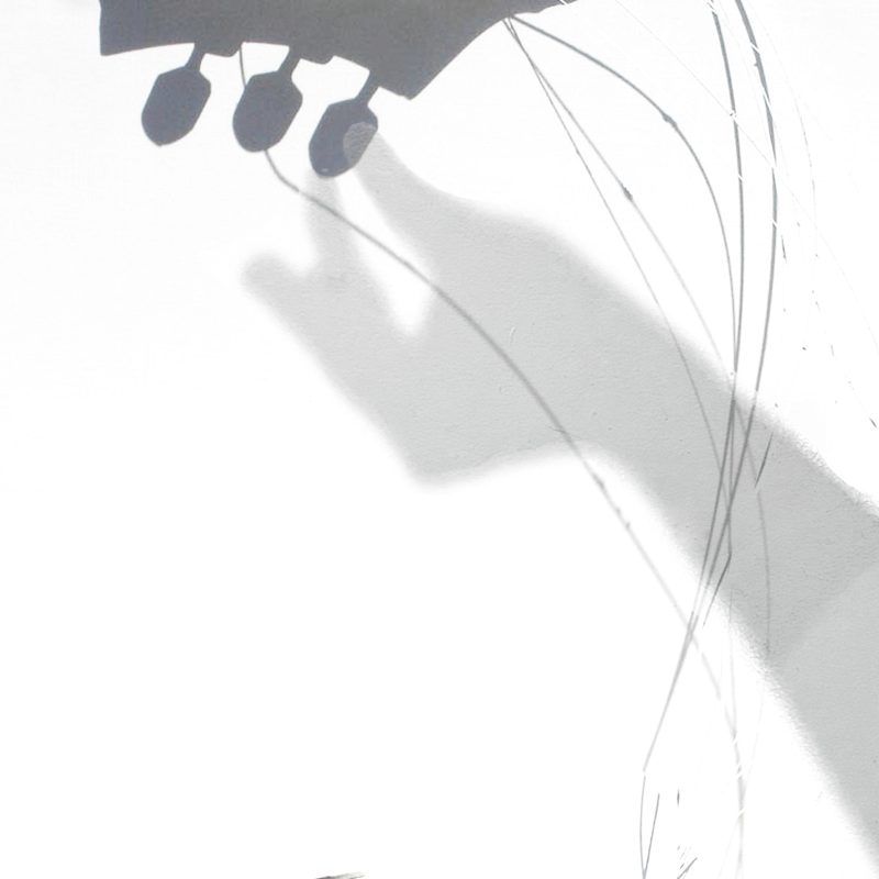 red soundhole headstock broken guitar strings shadow of hand