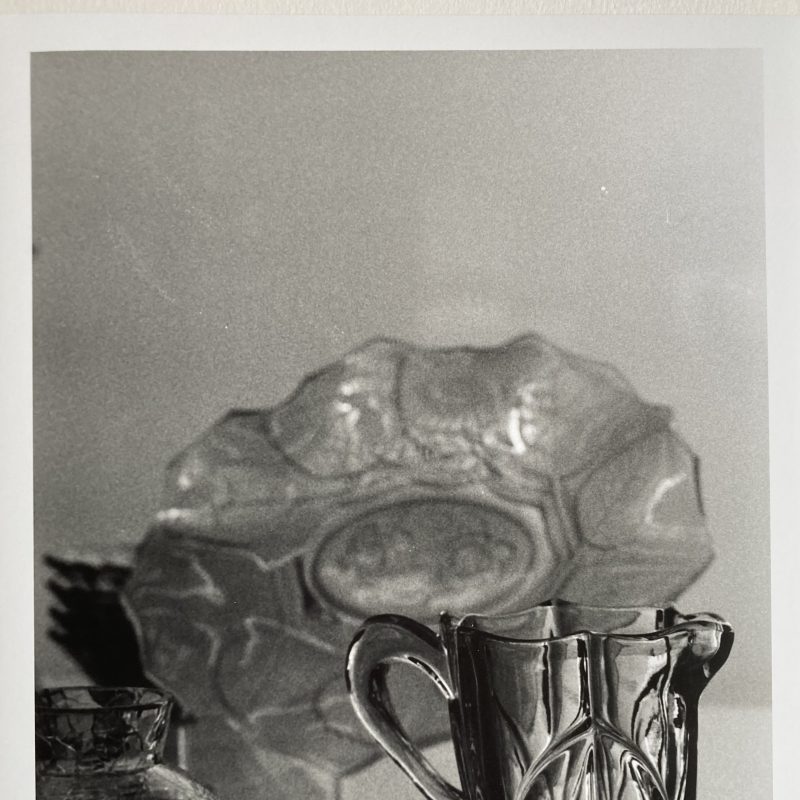 Three delicate, antique glass objects, on a shelf in a museum.
