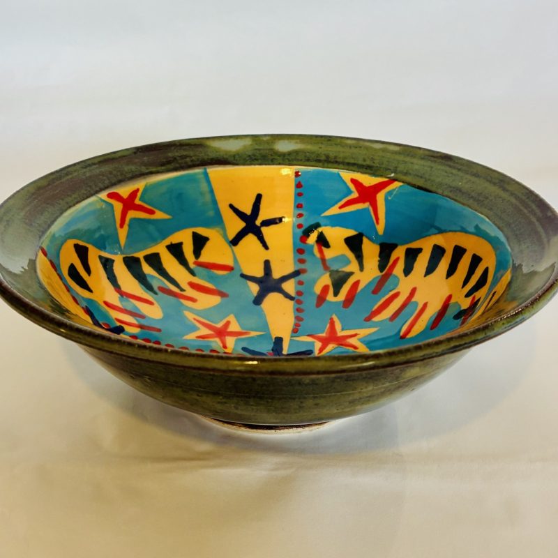 Brightly coloured, circular ceramic fruit bowl