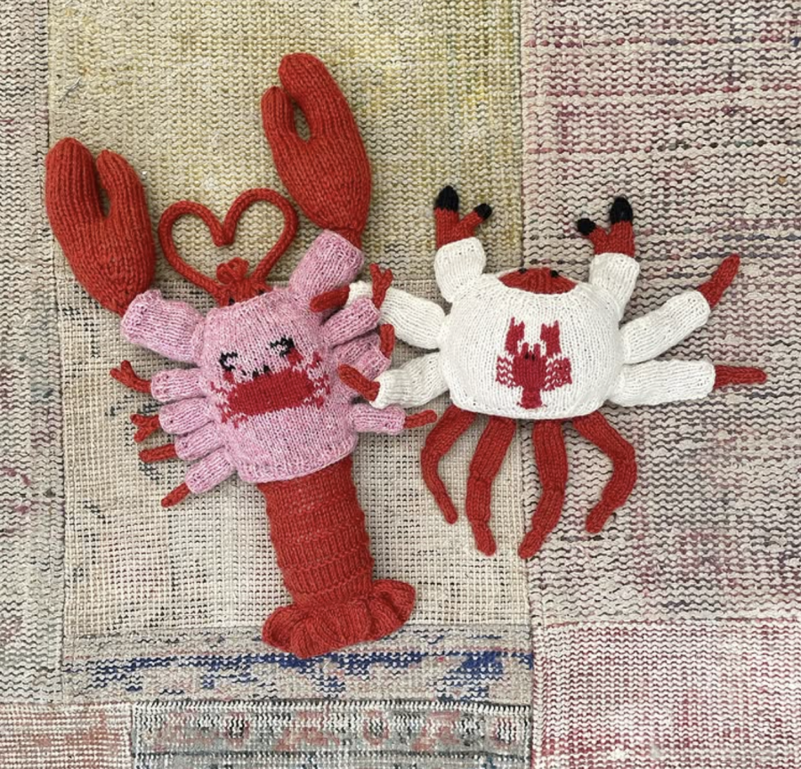 A hand-knitted crab and lobster wearing sweaters