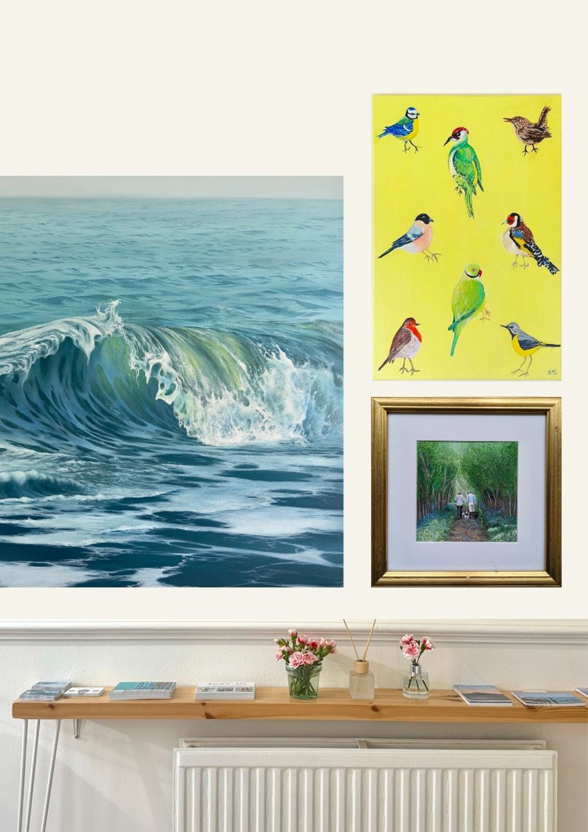 Three paintings on a wall, a seascape, landscape and birds