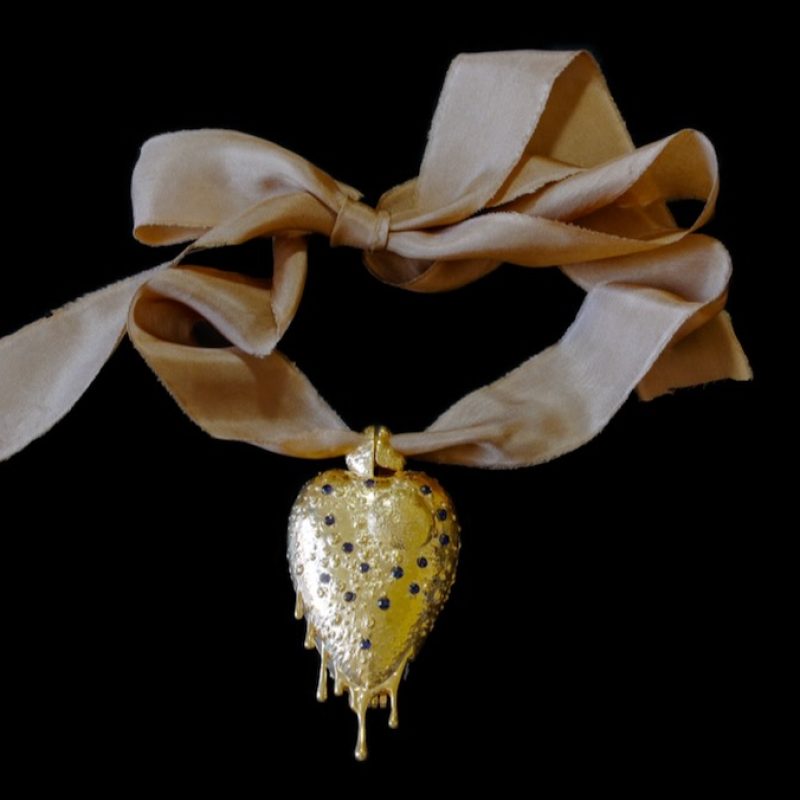 Gold and sapphire pendant on beige ribbon