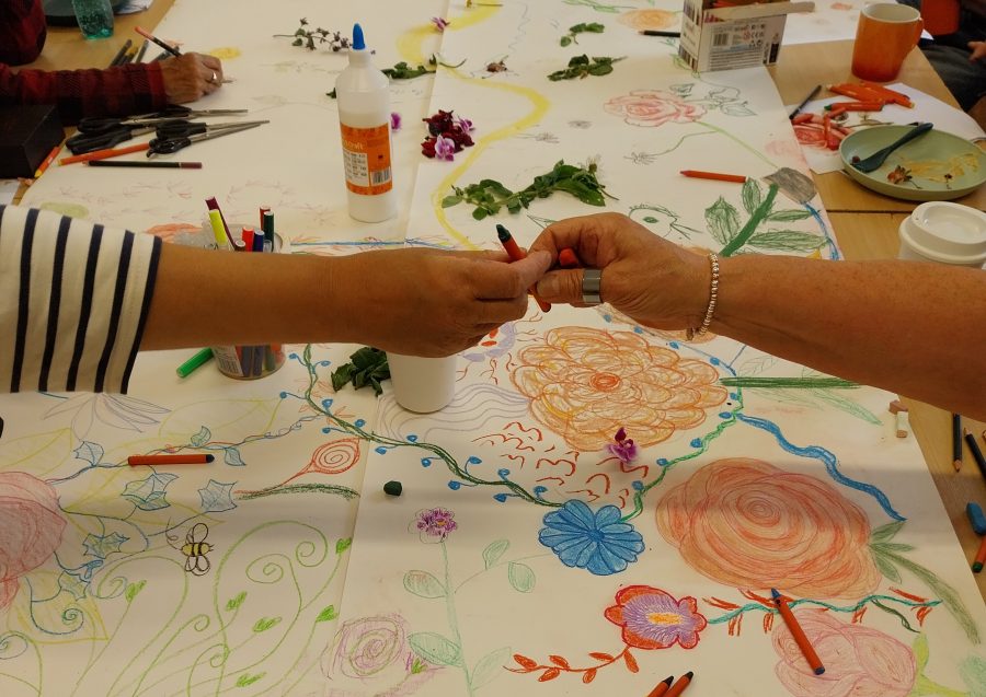 Two hands, holding a crayon. 