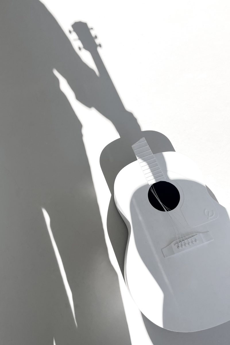 A broken white acoustic guitar red soundhole