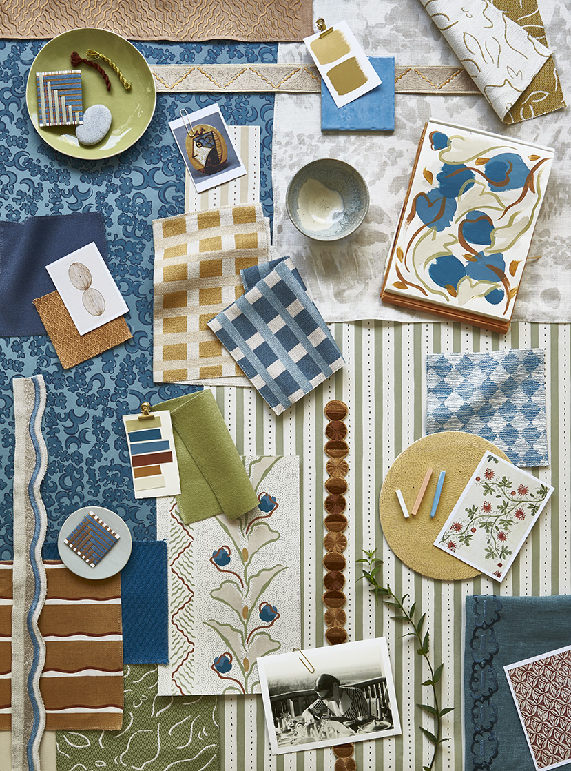 Design mood board leaning again a studio wall, featuring samples of patterned fabrics, wallpapers and trims.  