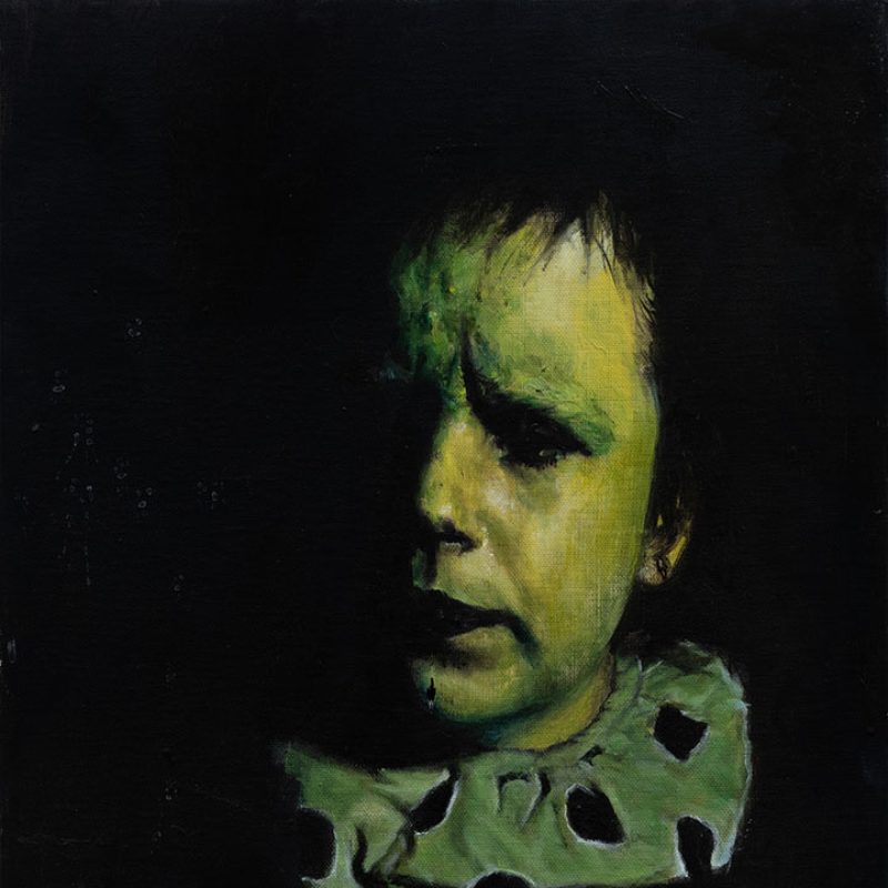 A partially visible self portrait of the artist dressed as a clown with mainly black background and shadows and greens and creams for the face and clown colar.
