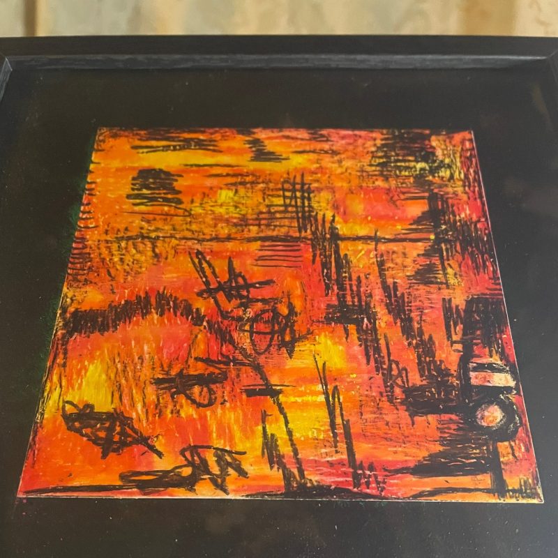 A red, orange, yellow background with black accents abstract piece on 14cm x 14cm card in a black framed picture frame