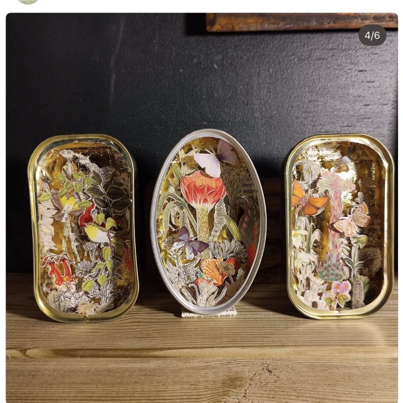 Three sardine tins with paper cut scenes