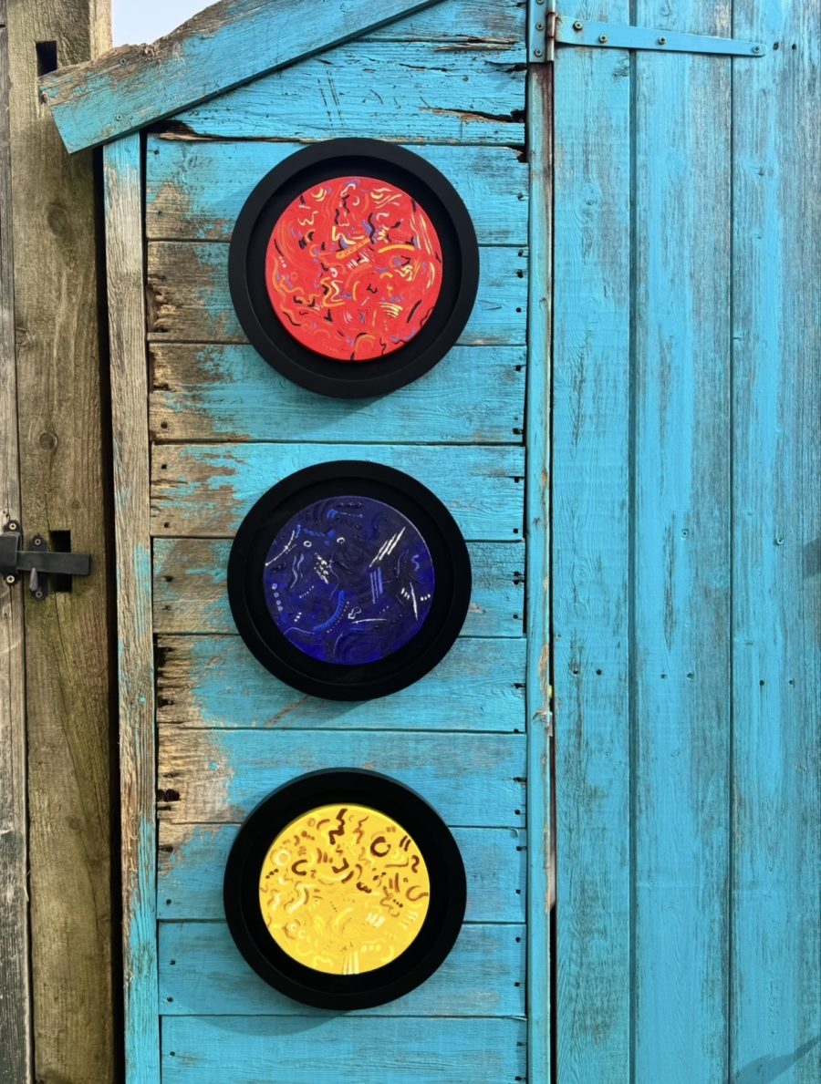 Three discs red, blue, yellow with abstract marks representing sound using colour 