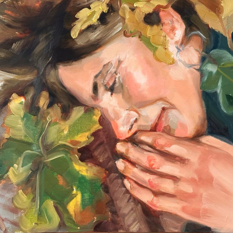 Portrait of a womanlying on a bed of leaves.