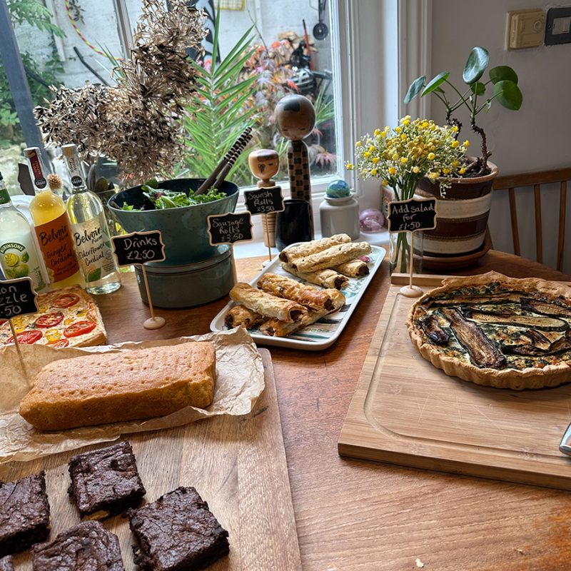 Kitchen tables with cakes a quiche and chocolate brownies