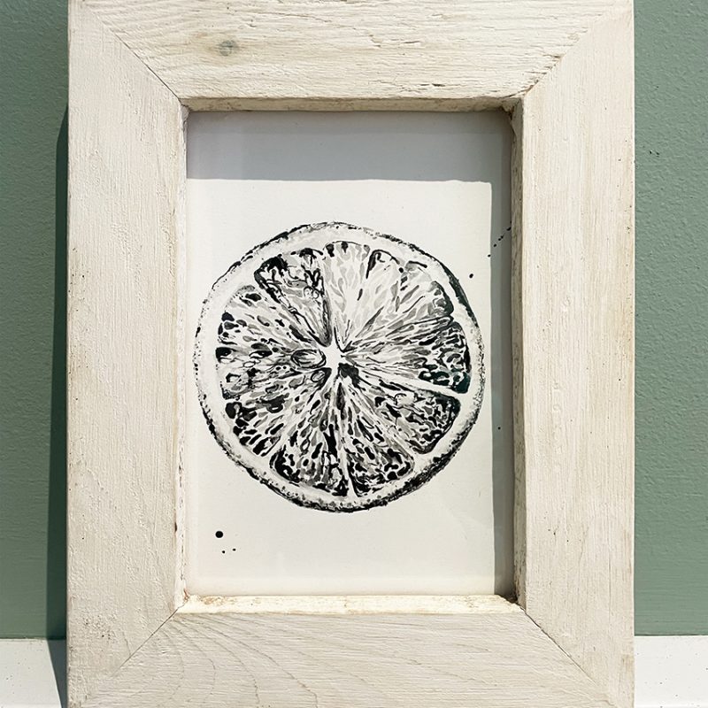Portrait white wood frame featuring a detailed black illustration of the inside of a sliced lemon 