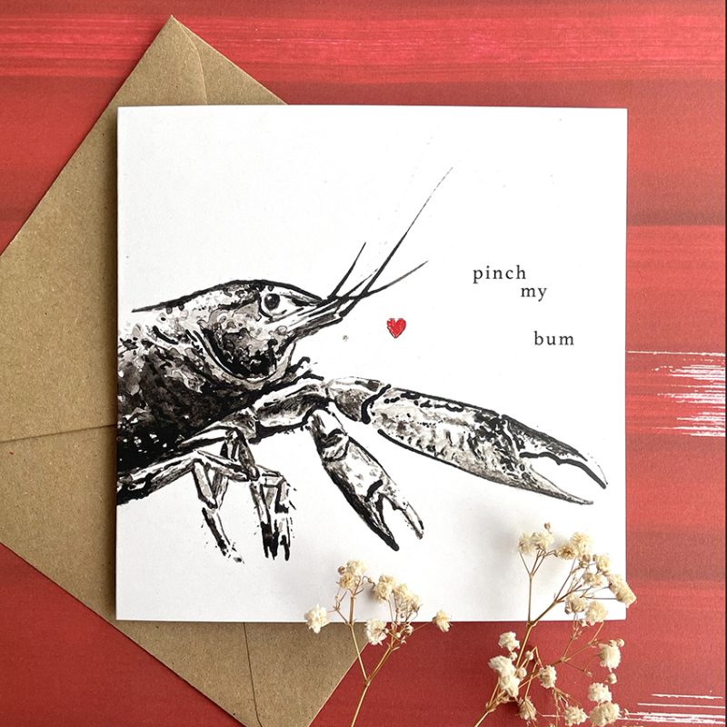 square white card featuring a black drawing of a lobster and a heart and the words 