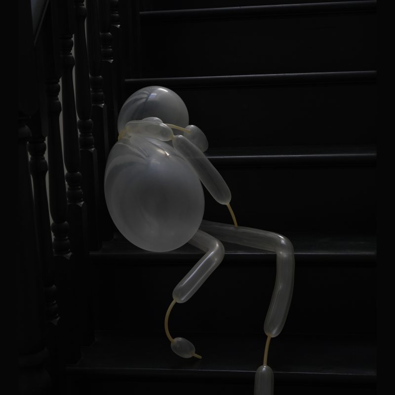 A balloon figure sits on a black staircase