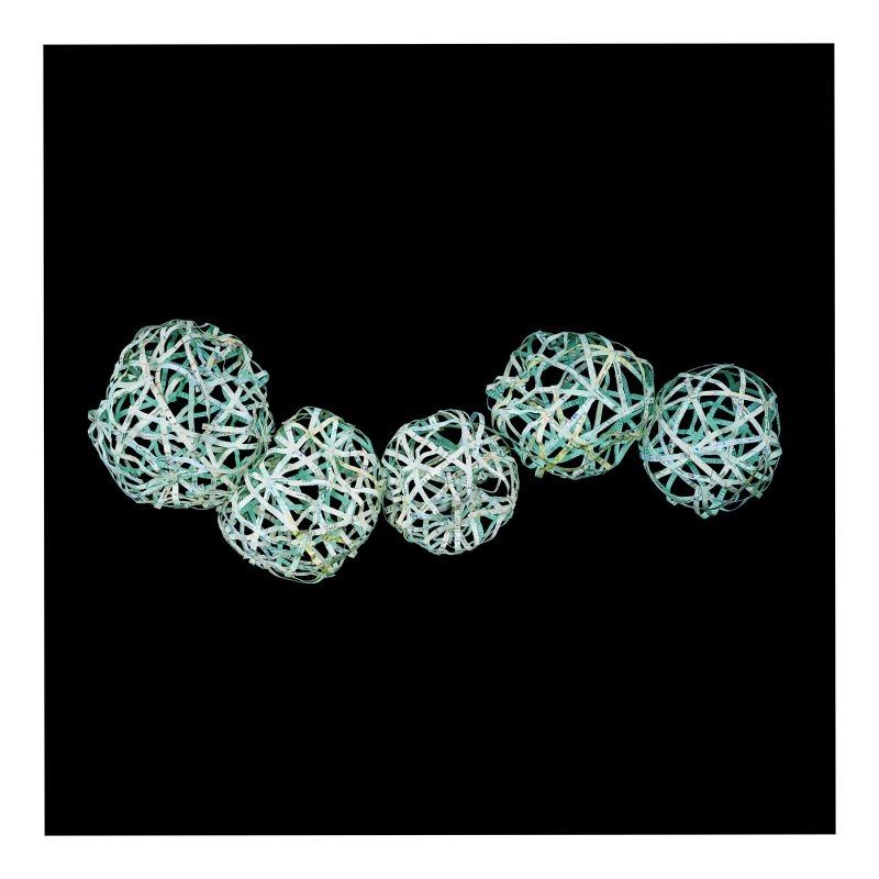 Four round shapes created from thin strips of a map of Nepal tumble across a black background.