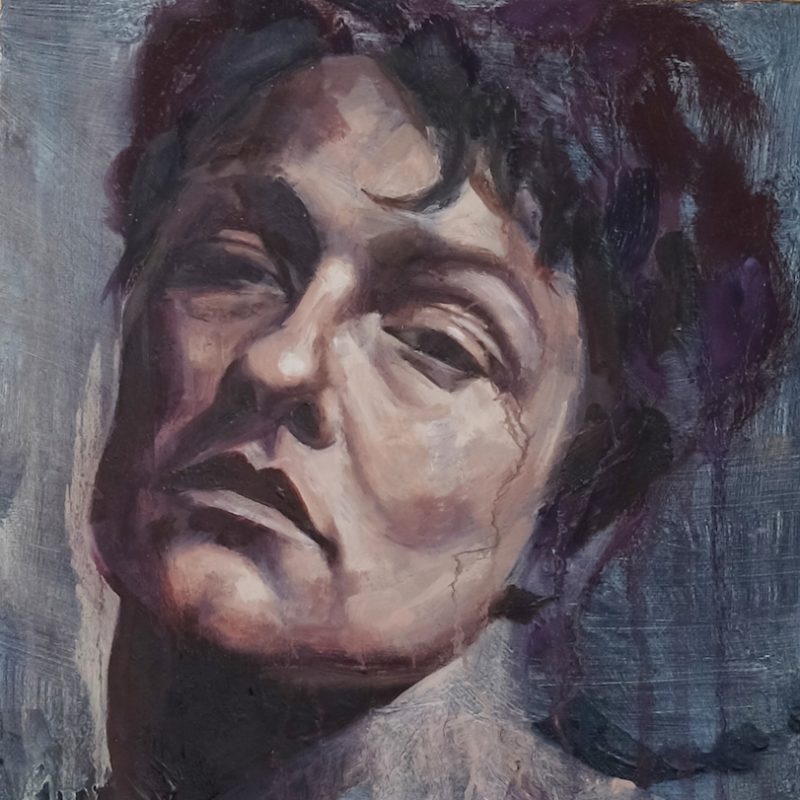 Head and shoulders portrait of woman with arresting, neutral expression in somber palette