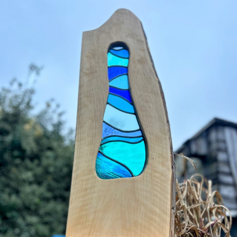 Blue glasses showing the colours of the sky in a natural wooden frame