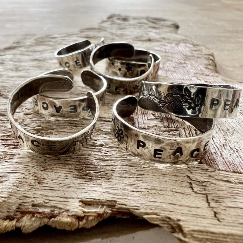 silver rings stamped with the word 'peace'