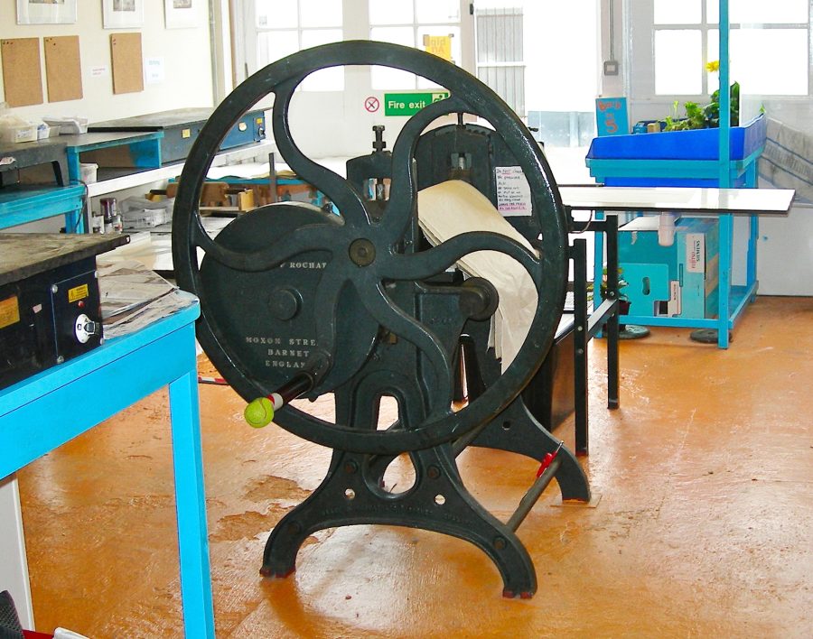 A large printing press with a turn wheel 
