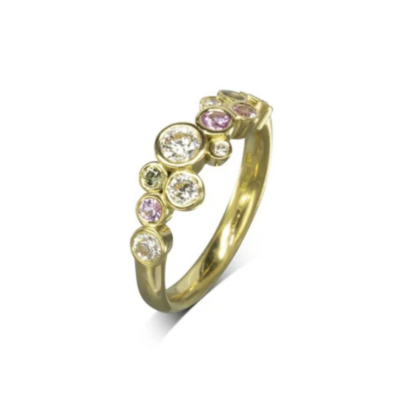 round brilliant cut diamonds and green and pink sapphires ranging from 1.8mm to 3.5mm set in gold settings in an irregular pattern on a gold band
