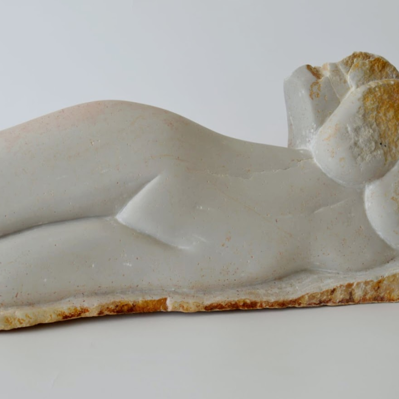Beautiful supine smooth sculpture of a womans reclininfgfigure,fromtheneck to thethighs,in soft chalky white