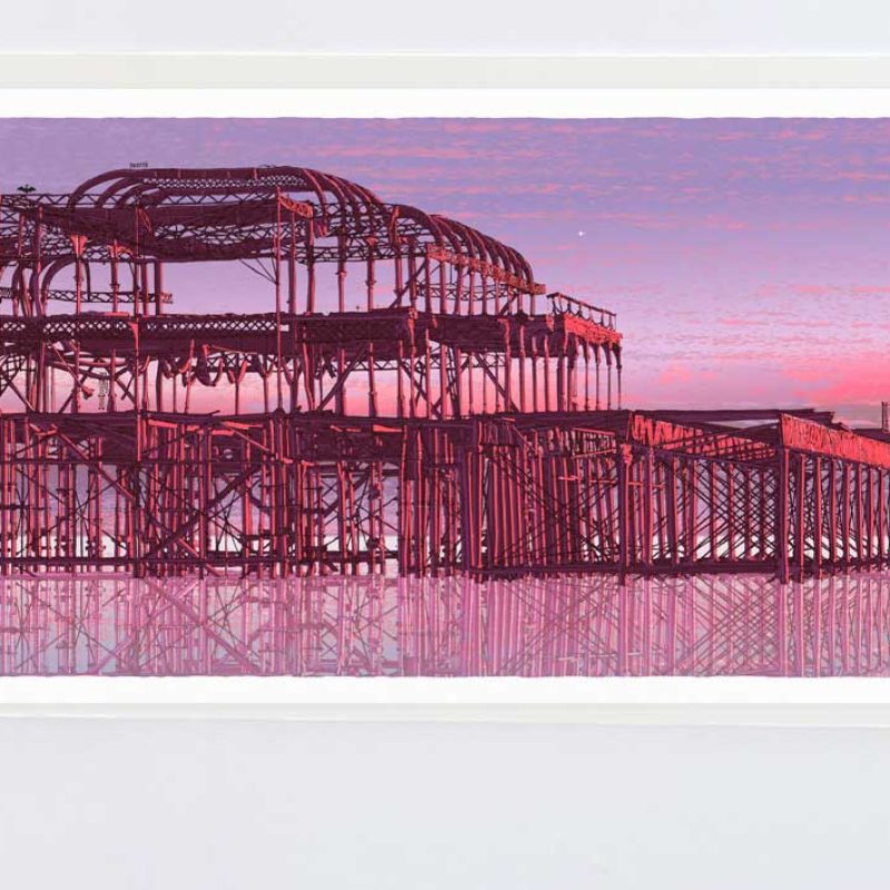 West Pier Cormorants Belt of Venus  The remains of the iconic Brighton West Pier and the Rampion Wind Farm rest on a perfect, still sea in the evening light. Cormorants and other birds gather as the light fades    New print series: The Belt of Venus The Belt of Venus is a soft pink glow that appears just before sunrise or after sunset, hovering above the horizon opposite the sun. It’s caused by sunlight scattering through the atmosphere, often separated from the horizon by the darker band of Earth’s shadow. In winter, the colour can feel sharper and more vivid.  I’m often looking up—through windows at night, cycling along the seafront, or walking past Brunswick Square in Hove. These skies, along with childhood evenings spent studying constellations with a torch and a sky map, have led to a new series of prints.