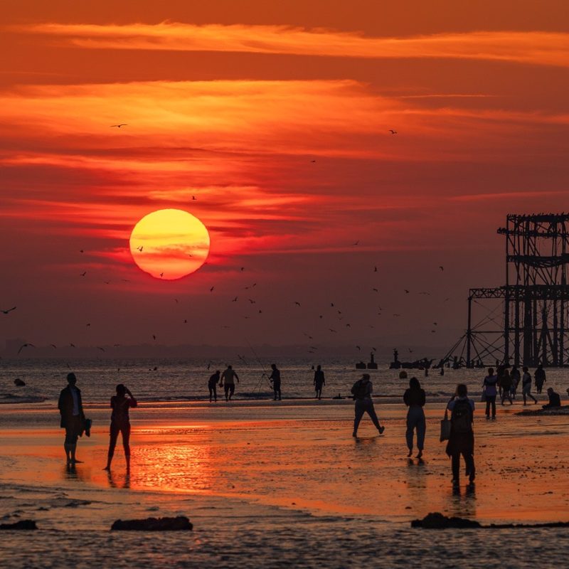Photograph of the West pier and beach at a red Sunset