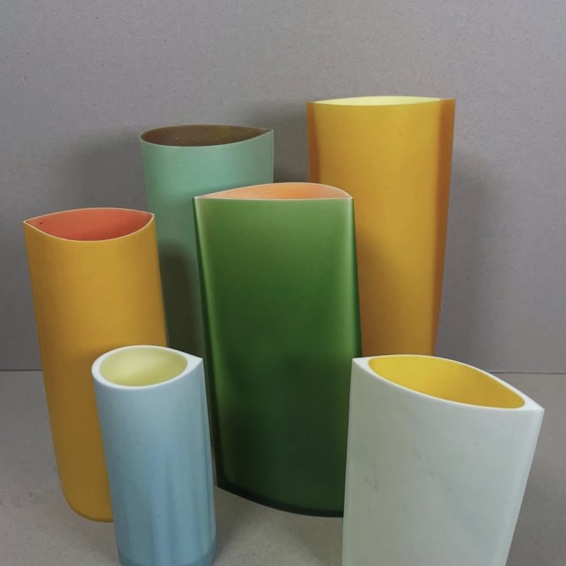 Resin Vessels in bold colours of Green, Yellow, Blue and Orange agaist a grey background