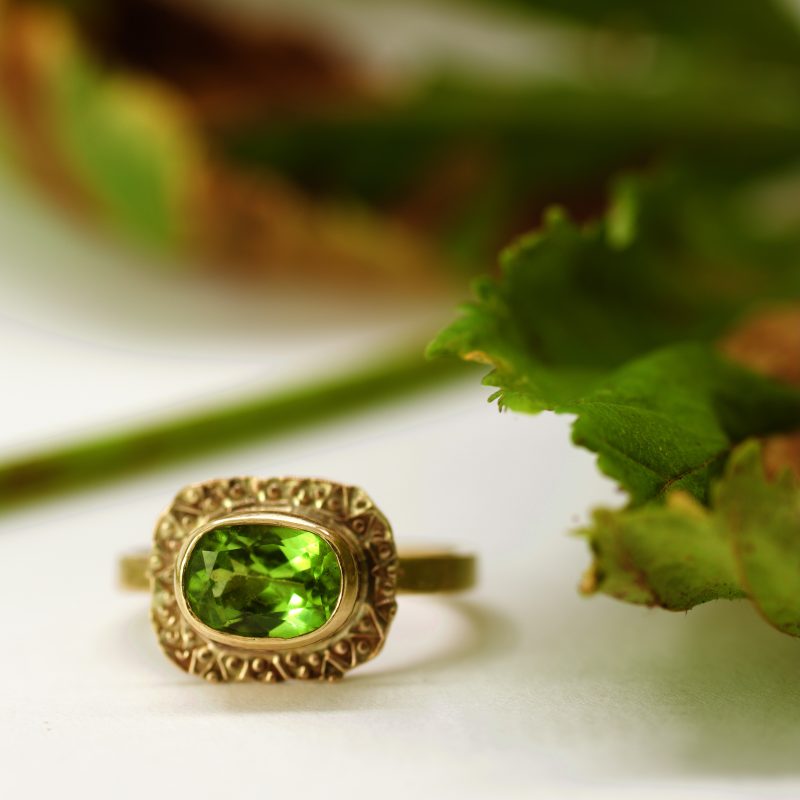 A gold ring with a green stone